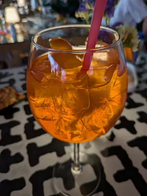 orange coloured non alcoholic drink standing on a black and white patterned table